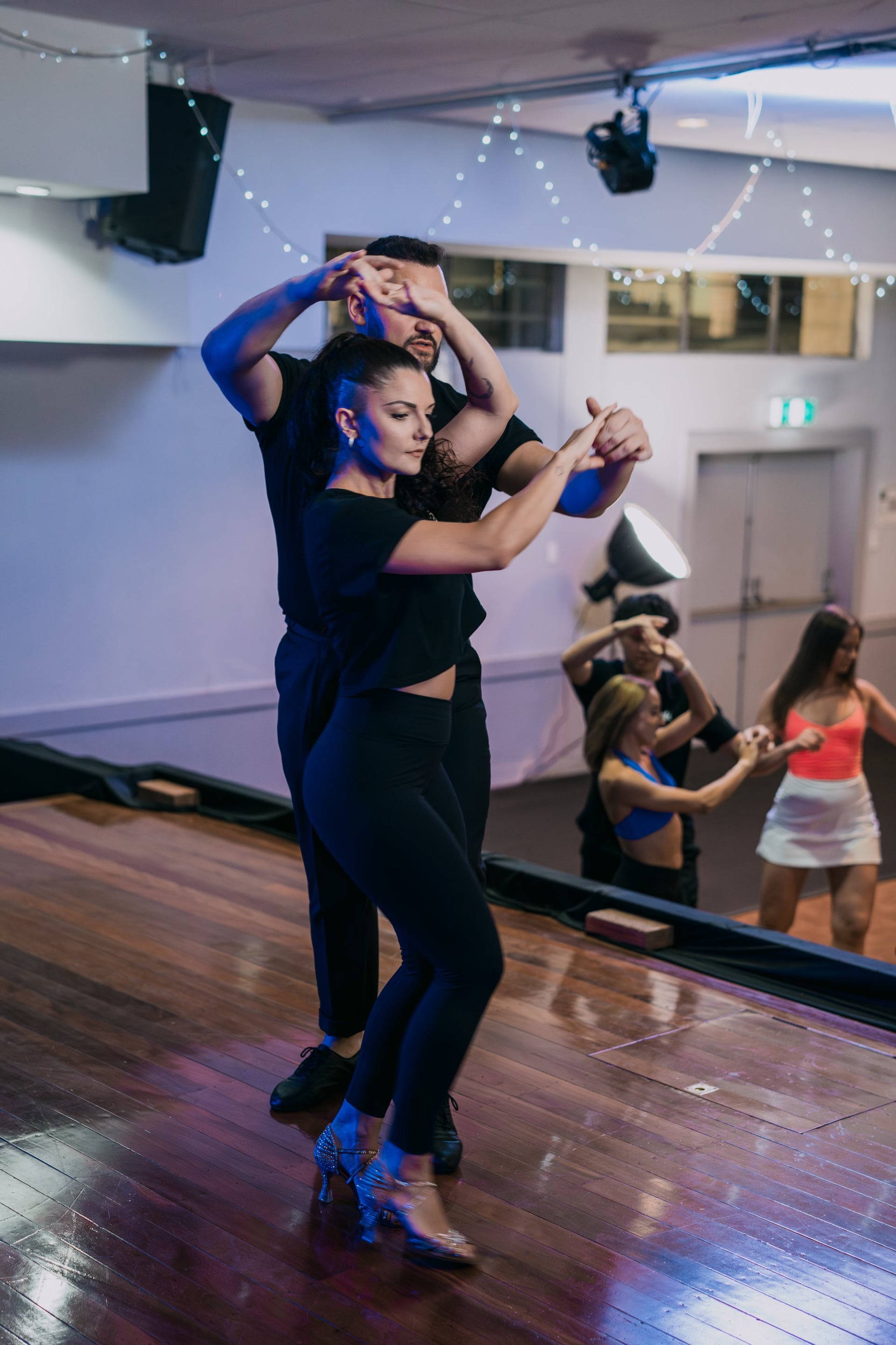 Alex and Madalyn dancing on stage in front of the class